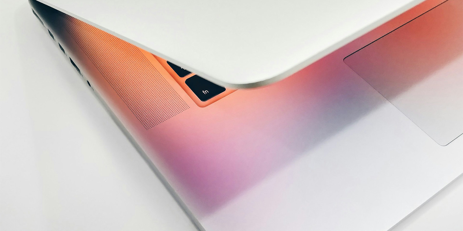 Ein halb-geöffnetes MacBook vor weißem Hintergrund